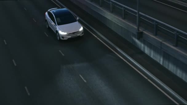 Flygdrönare Visa av en modern lyx Vit Elektrisk SUV Köra på Urban Highway på natten. Batteridriven bil Aktiverar vändsignal och byter körfält. Futuristisk bil med Xenon strålkastare. — Stockvideo