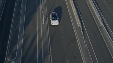 Slow Motion Aerial Drone Modern Lüks Beyaz Elektrikli arazi aracı görüntüsü. Pilli araba Boş Ekspres Yolu 'ndan geçiyor. Panoramik Çatı ile Geleceğin Çaprazlaması.