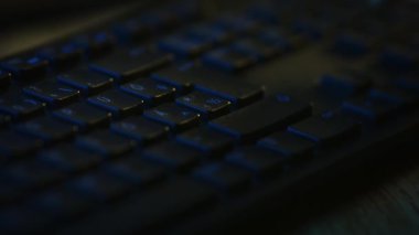 Yakın plan Makro Çekim: Siyah Bilgisayar Klavyesi Kullanan Kişi, Enter Tuşu 'na basın. Çalışmak, e-posta yazmak, internet kullanmak. Koyu ve Mavi Renkler