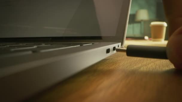 Makroaufnahme aus nächster Nähe: Laptop auf dem Schreibtisch, Person steckt USB-C-Kabeladapter in Computeranschluss. — Stockvideo