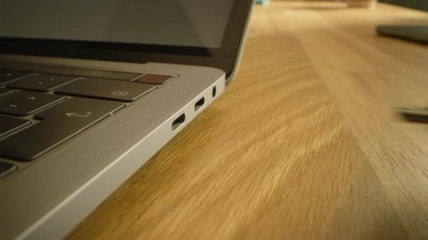 Närbild Macro Shot: bärbar dator på skrivbordet, person för in USB-C-kabel adapter i datorporten. — Stockvideo