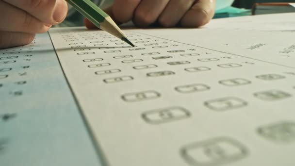 Lors de l'examen, la personne testée colore les bonnes réponses avec un crayon. Remplissage de la feuille de réponse avec des tests standardisés, marquage des bulles de réponse correctes — Video