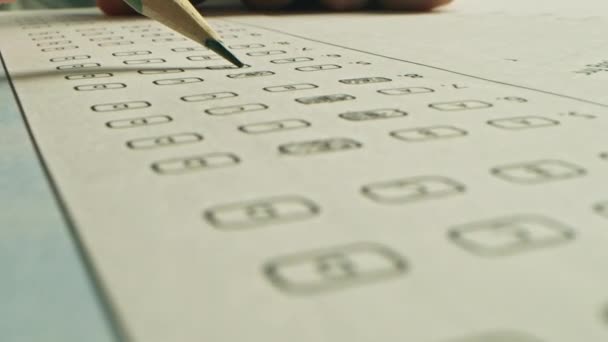 Bei der Prüfung färbt Testperson die richtigen Antworten mit einem Bleistift. Füllen des Antwortbogens mit standardisierten Tests, Markieren korrekter Antwortblasen — Stockvideo
