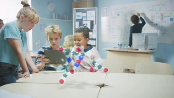 Três crianças da escola diversa na classe da ciência da química usam o computador digital da tabuleta com aplicação aumentada da realidade, olhando para a animação 3D educacional de uma molécula. VFX, renderização de efeitos especiais — Vídeo de Stock