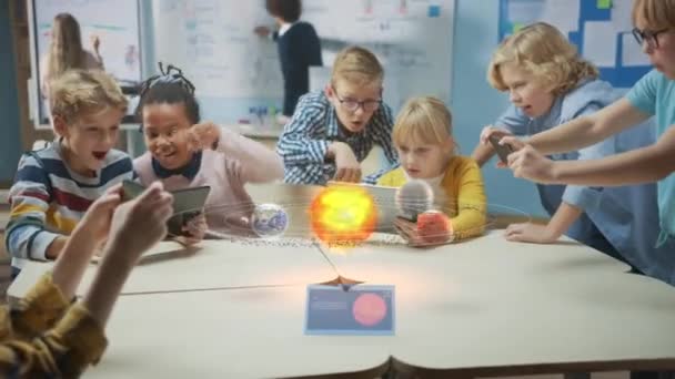 Skupina školních dětí ve vědecké třídě Použijte digitální Tablet počítače s rozšířenou realitou software, Při pohledu na vzdělávací 3D animace sluneční soustavy. VFX, vykreslení speciálních efektů — Stock video