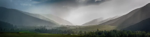 Bolyhos esős felhők, zöld dombokon — Stock Fotó
