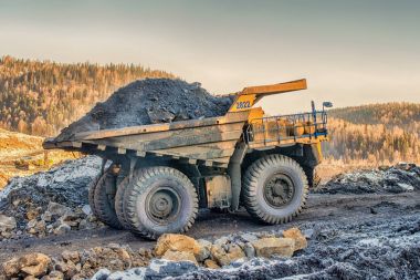 Big yellow loaded dump truck and  in the coal mine before forest clipart