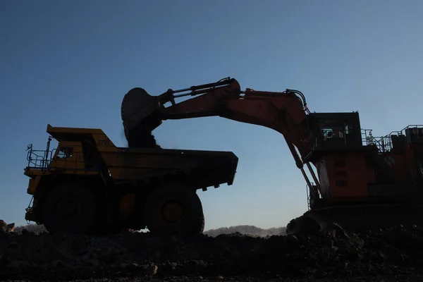 Big yellow dump truck and excavator in coal mine at sunrise — Stock Image Big Yellow Dump Truck Excavator Coal Mine Sunrise Stock Photo