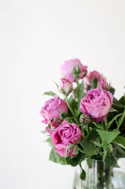 Pembe gül çiçekleriyle dolu bir vazo.