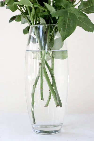 Um buquê de flores em um vaso de vidro transparente — Fotografia de Stock