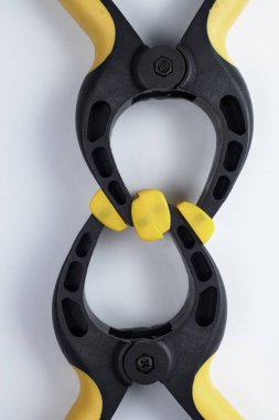 Siyah ve sarı kıskaçlar birbirine bağlanmış. Beyaz arkaplanda yakın plan