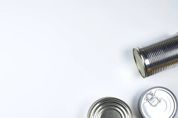 Latas de diferentes tamaños sobre un fondo blanco. espacio de copia —  Fotos de Stock