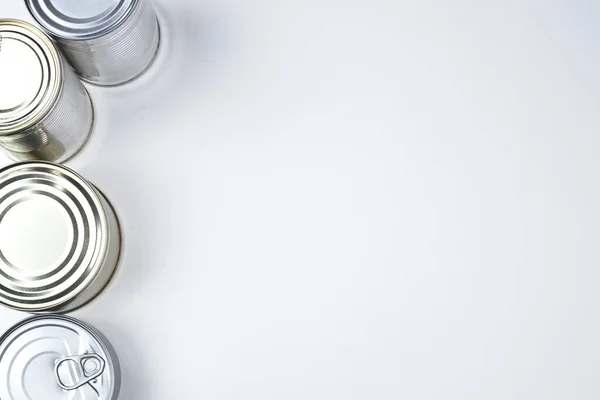 Latas de diferentes tamaños sobre un fondo blanco. espacio de copia . —  Fotos de Stock