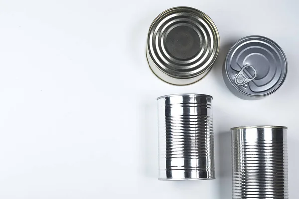 Latas de diferentes tamaños sobre un fondo blanco. espacio de copia . — Foto de Stock