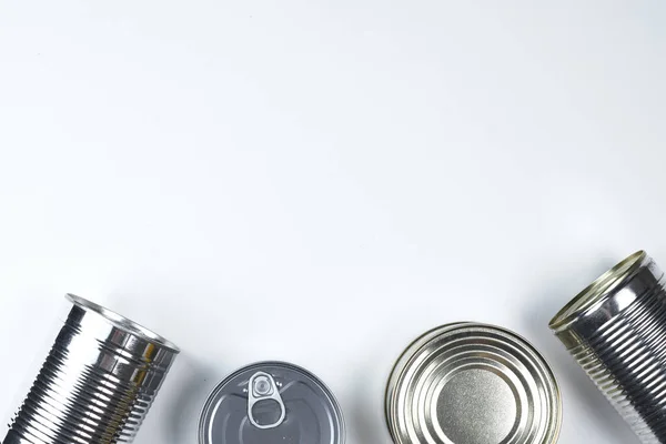 Latas de diferentes tamaños sobre un fondo blanco. espacio de copia . —  Fotos de Stock