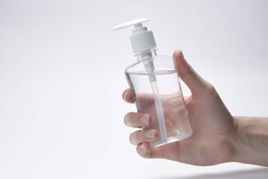 Beyaz arka planda şeffaf bir şişe, şişe ya da jel, krem ya da antiseptik için konteynır tutuyor. kopyalama alanı