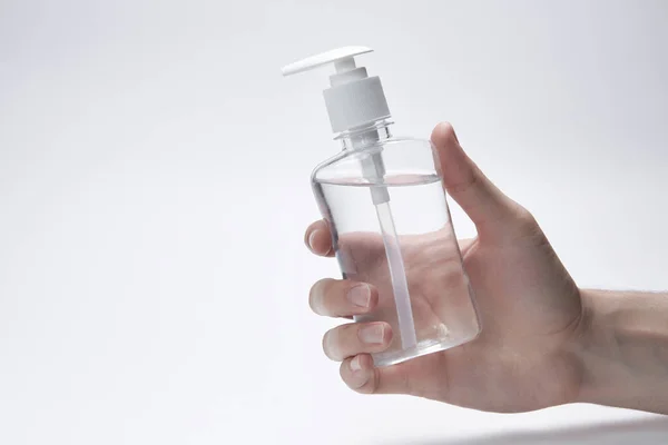 손에는 흰 바탕에 투명 한 병, 병 혹은 젤 , 크림 , 살균제등을 담은 용기가 들어 있다. copyspace 스톡 이미지