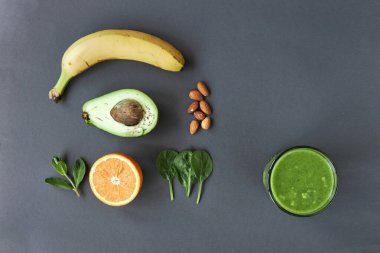 Muz, avokado, portakal, ıspanak, nane, fındık ve yeşil buzlu içecek. kopyalama alanı.