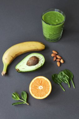 Muz, avokado, portakal, ıspanak, nane, fındık ve yeşil buzlu içecek. kopyalama alanı.