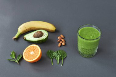 Muz, avokado, portakal, ıspanak, nane, fındık ve yeşil buzlu içecek. kopyalama alanı.