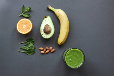 Muz, avokado, portakal, ıspanak, nane, fındık ve yeşil buzlu içecek. kopyalama alanı.