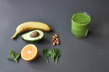 Muz, avokado, portakal, ıspanak, nane, fındık ve yeşil buzlu içecek. kopyalama alanı.