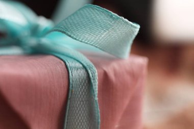 Yanında mavi fiyonk olan pembe hediye kutusu. Makro çekim.