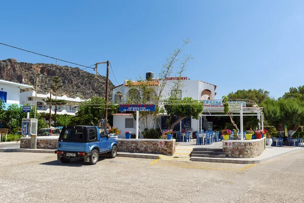 Tradiční řecké taverně s zaparkované auto modré. — Stock fotografie