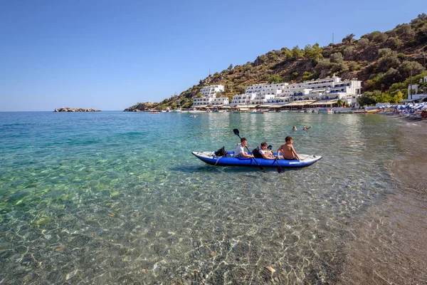 Ladí chlapci plavba v kánoi u pobřeží Loutro města na ostrově Kréta, Řecko. — Stock fotografie