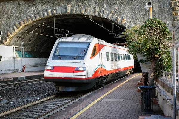 Tren blanco de pasajeros saliendo del túnel cerca de la ciudad de Vernazza, Cinque Terre, Italia — Foto de Stock