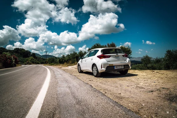 Bílá Toyota Auris zůstává zaparkovaného mezi mraky na silnici z ostrova Kréta. — Stock fotografie