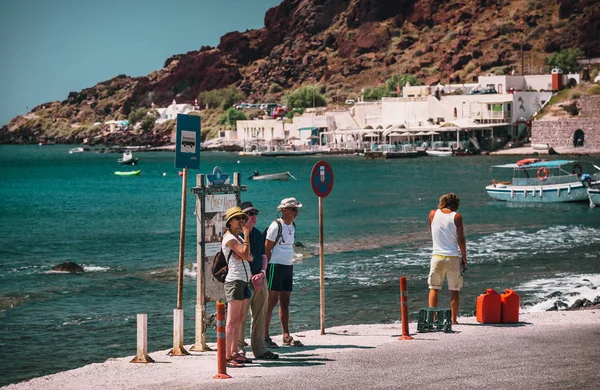 Lidé jsou ubytováni na autobusové zastávce a čekání na autobus nedaleko města Akrotiri na ostrově Santorini — Stock fotografie