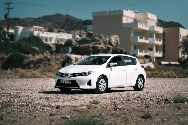 Beyaz Toyota Auris Crete Adası yolda park edilmiş kalır.