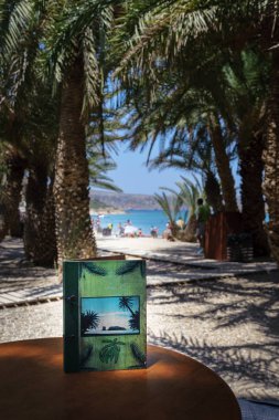 Ahşap masa Vai Palm Beach Crete adada yeşil kitap
