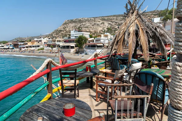 Paraguas hecho de hojas de palma en hermoso bar hippie en la costa de la bahía de Matala en la isla de Creta, Grecia — Foto de Stock