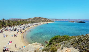Turistlerin adada Crete, Yunanistan kumlu plajda güneşlenirken