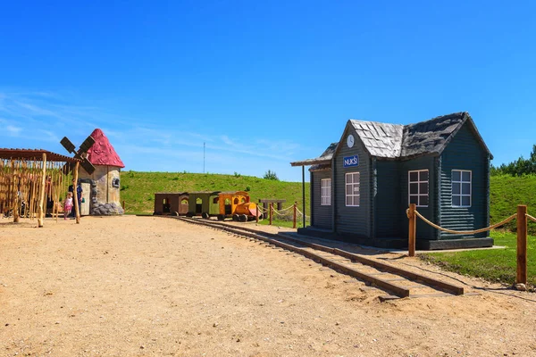 Заброшенный детский парк с деревянными моделями железнодорожного вокзала и ветряной мельницы — стоковое фото