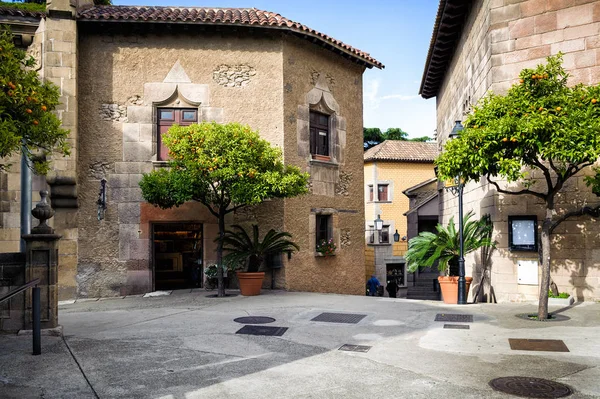 Traditional medieval square with citrus trees in Spanish village (Poble Espanyol) at Barcelona town, Catalonia, Spain — Stock Photo, Image