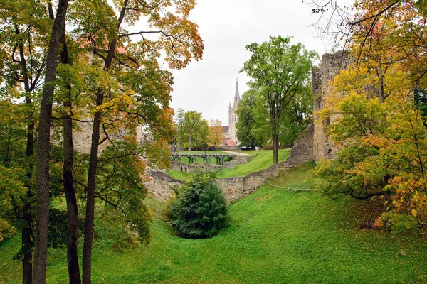 Parque de outono com ruínas medievais em um fundo na cidade de Cesis, Letônia — Fotografia de Stock