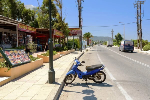 Mavi scooter Kiralama Rodos Adası üzerinde geleneksel Yunan tavernası yakınındaki park edilmiş kalıyor