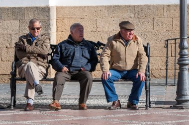 Ronda, İspanya - Aralık 2017: Üç Büyükler düzeyinde men bir bankta oturuyorlar
