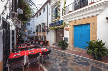 Marbella, İspanya - Aralık 2017: Dar sokak tarihi şehrin hizmet masaları ile
