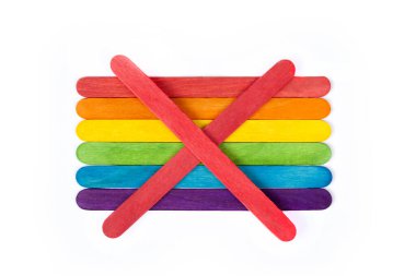 Dondurma ve dondurma çubuklarından yapılmış gökkuşağı bayrağının üzerinde kırmızı bir X sembolü. Beyaz arka planda izole edilmiş LGBT topluluğuna ve ayrıcalıklara karşı olmak