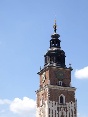 Belediye binası kulesi, arka plan olarak mavi bulutlu gökyüzü. Cracow, Ana Pazar Meydanı 'nın ünlü simgeleri. Kartpostal gibi, güneşli bir gün.