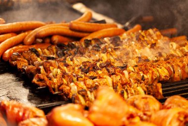 Bir sürü lezzetli şiş kebap, sosis ve açık havada ızgara et. Farklı et türleri, bbq konsepti. Duman yukarıda, yemek fotoğrafçılığı, odak noktası, sıcak renkler. Macro, kapat.