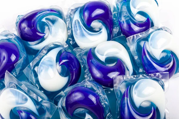 Many simple blue white detergent pods. Lots of washing machine pods macro, closeup. Home domestic equipment, cleaning washing dishes and doing laundry, group of home chemicals abstract concept