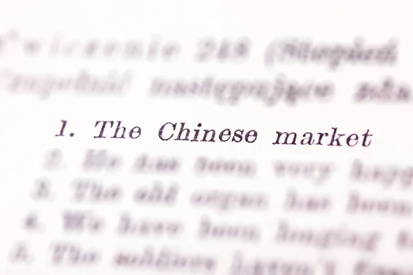 The Chinese market text highlighted, pointed out in a book, number one in a list, selective focus. China economy on the first place, printed priority list, economical issues concept