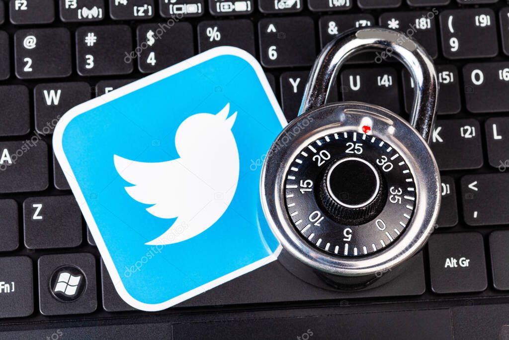 Twitter account password security simple abstract concept. Twitter service logo and a metal coded padlock, lock laying on a black laptop keyboard