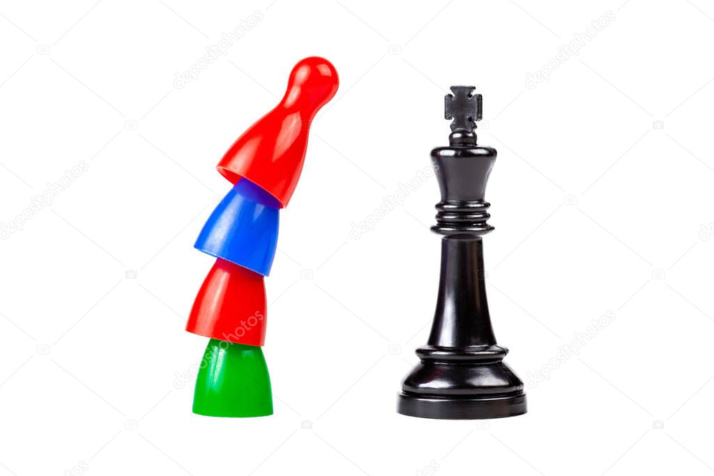 Teamwork against the ruler, revolution against authority. Traditional game pieces standing on top of each other in front, above a black king chess piece. Workers conflict of interests, inequality