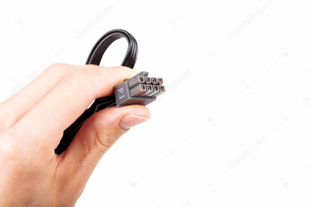 Hand holding up in fingers, presenting one single pc power supply unit black P1 8 eight pin PCI express cable with grey connector isolated on white closeup PSU PC components powering solo cord concept